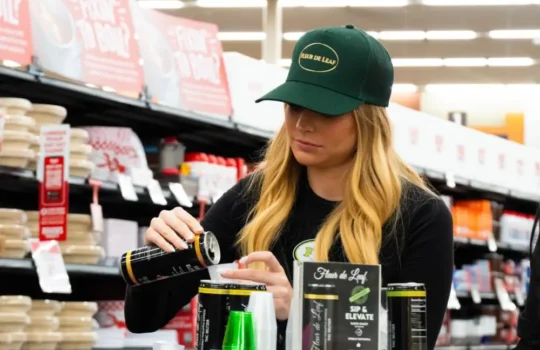 A Fleur de Leaf representative in a store giving customers THC beverage samples.